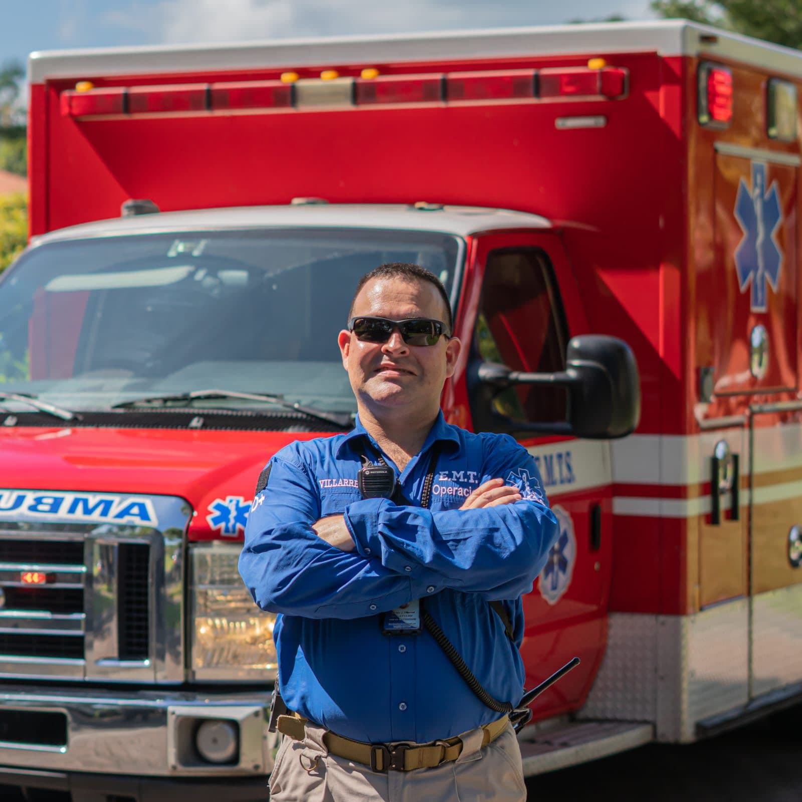 Arturo Villarreal con uniforme de operaciones de EMTS junto a una ambulancia