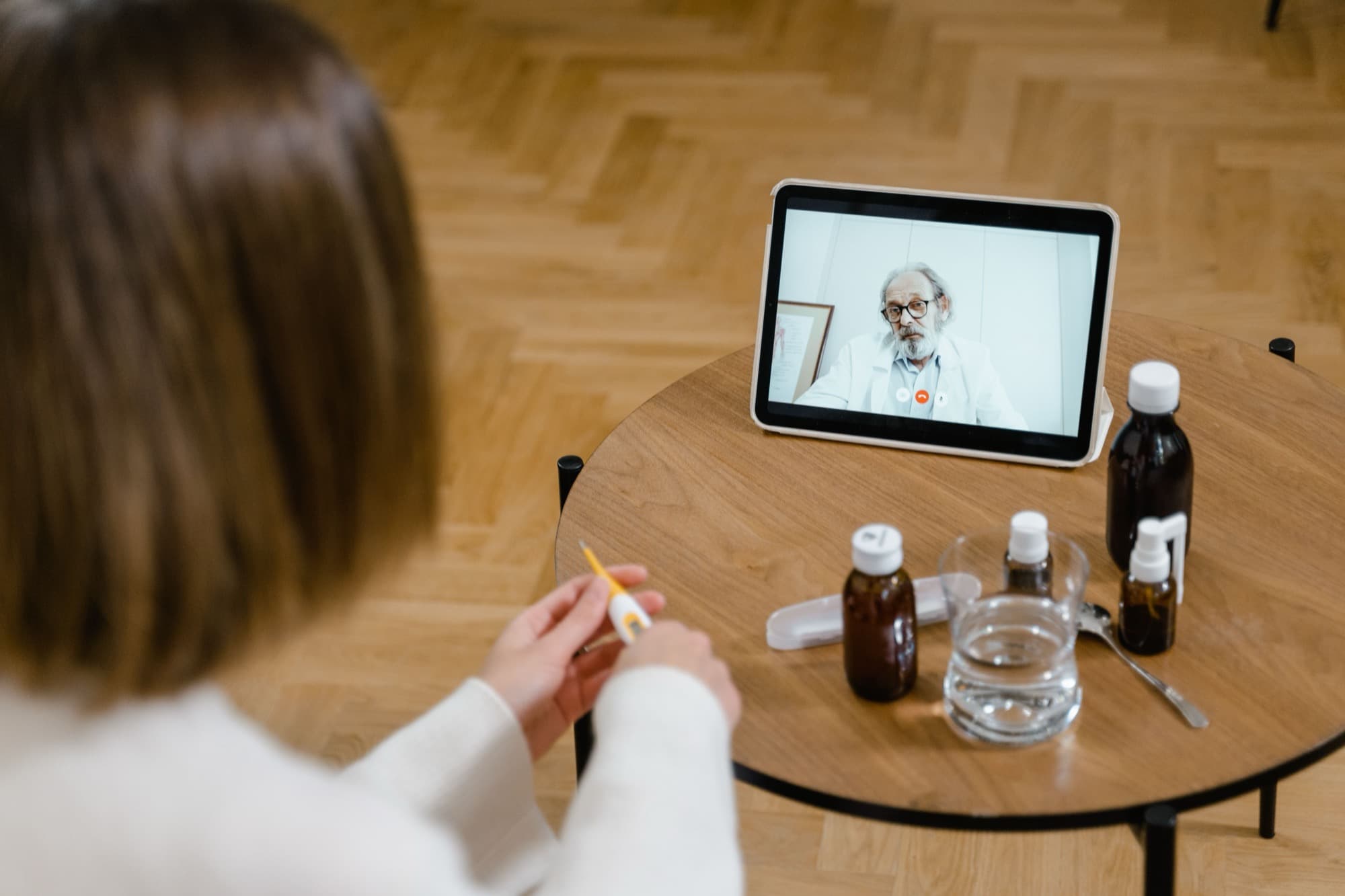 Un paciente en casa consultando a un médico por videollamada en una tableta